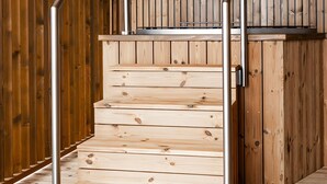A wooden staircase with metal handrails, leading to a higher level.