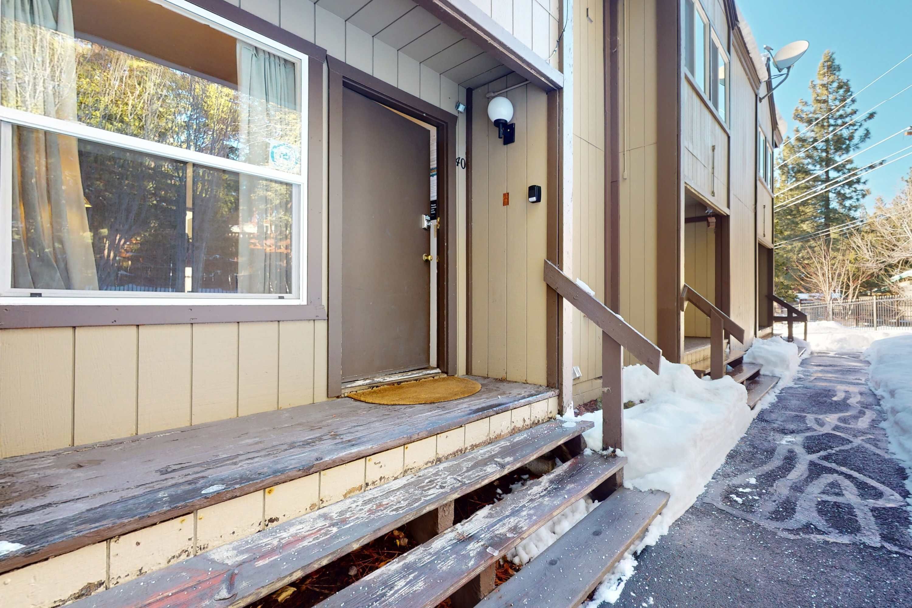 A building with a wooden front porch, a door, and a satellite dish.