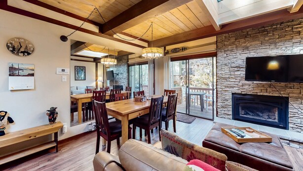 Un interior moderno con comedor, chimenea y ventanas amplias.
