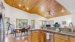 Una cocina moderna con armarios de madera, encimeras de granito y lavavajillas integrado.