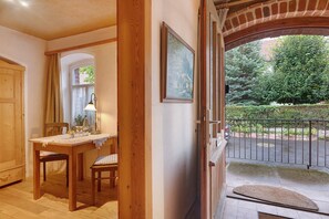 A wooden interior with a dining area, a door leading outside, and a view of a garden. - Guest House 'Heuhof-Breiau Gästedoppelzimmer' with Shared Terrace, Shared Garden and Wi-Fi (Sontra)