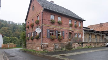 Ein rotbacksteiner Gebäude mit steilem Dach, zahlreichen Fenstern und Blumenkästen im zweiten Stock.