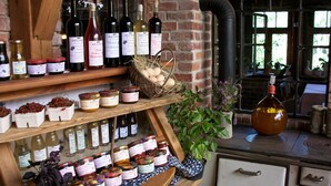 A wooden shelf with wine bottles, jars of preserves, and a basket of eggs. - Guest House 'Heuhof-Breiau Gästedoppelzimmer' with Shared Terrace, Shared Garden and Wi-Fi (Sontra)