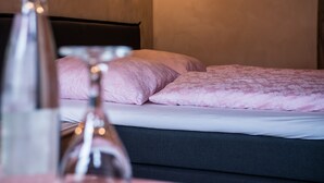 A bed with a dark headboard, a wall-mounted light, and a bottle on the side table. - Guest House 'Heuhof-Breiau Gästedoppelzimmer' with Shared Terrace, Shared Garden and Wi-Fi (Sontra)
