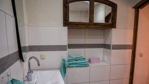 A bathroom with a white sink, a mirror, a towel rack, and a wooden cabinet. - Guest House 'Heuhof-Breiau Gästedoppelzimmer' with Shared Terrace, Shared Garden and Wi-Fi (Sontra)