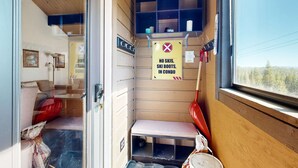 Una stanza piccola con una panca, una finestra e un cartello che vieta l'ingresso a sci e scarponi da sci.