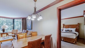 Een hotelkamer met een zithoek, een bed en een groot raam met uitzicht.