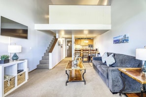 A modern living room with a sofa, coffee table, and a staircase leading to a kitchen. - Experience Laid-back Mountain Living at this Townhome w Beach, Pool and Spa (South Lake Tahoe)