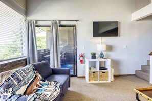 A living room with a sofa, a TV, a lamp, a small table, a bookshelf, and a fire extinguisher. - Experience Laid-back Mountain Living at this Townhome w Beach, Pool and Spa (South Lake Tahoe)