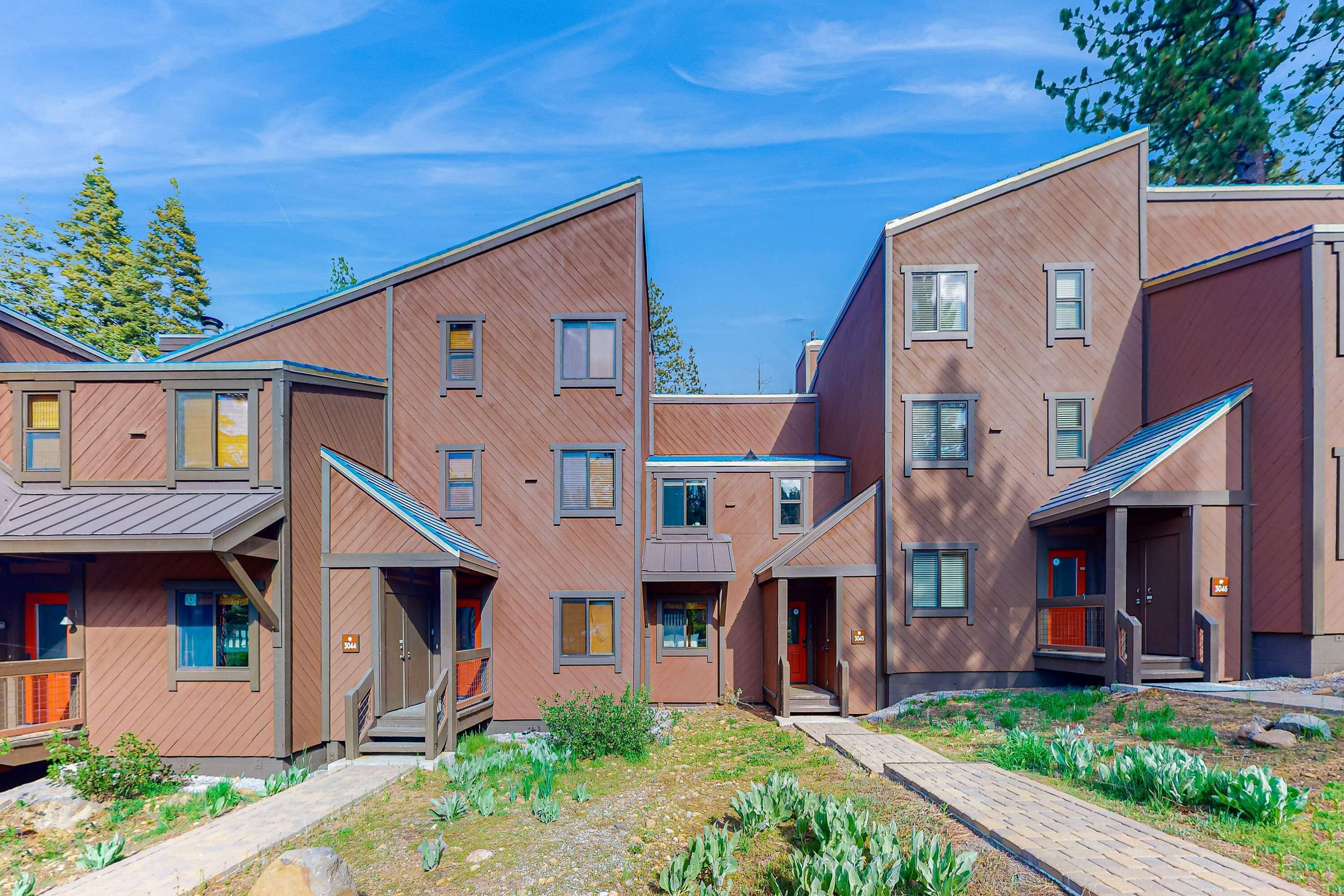 Un immeuble résidentiel moderne à plusieurs étages, doté d’une cour intérieure, de balcons et d’une variété de styles de fenêtres.