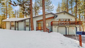 A two-story house with a balcony, a garage, and a snow-covered driveway. - Spacious home with a pool table close to golf, skiing, hiking & biking (South Lake Tahoe)