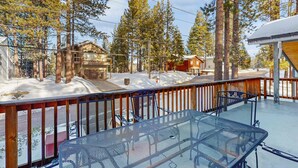 A metal table and chairs on a balcony with a view of houses and tall trees. - Spacious home with a pool table close to golf, skiing, hiking & biking (South Lake Tahoe)