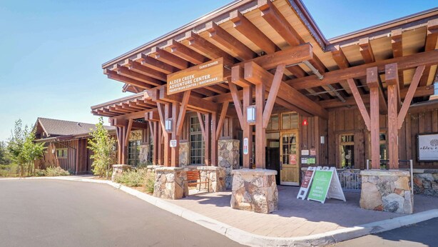 Un edificio in legno con un cartello che indica 'Alder Creek Adventure Center'.