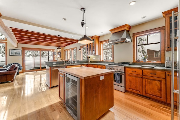 A spacious kitchen with wooden cabinets, a central island, and a large window.