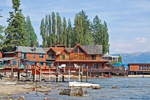A waterfront property with multiple buildings, docks, and boats. - Cute cabin with spacious porch, walk to beach & dining, central to ski resorts (Carnelian Bay)