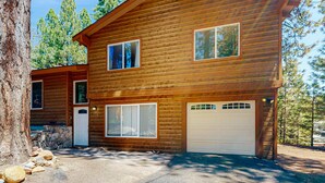 A two-story log cabin with a stone foundation, a white garage door, and a visible number '2045' on the front door. - Quiet mountain home with game room & fireplace - near scenic trails & ski slopes (Incline Village)