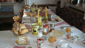 A table set with various breakfast items including bread, pastries, and beverages. - Apartment 'Nunnenmayr A' with Mountain View, Shared Garden and Wi-Fi (Tirolo)