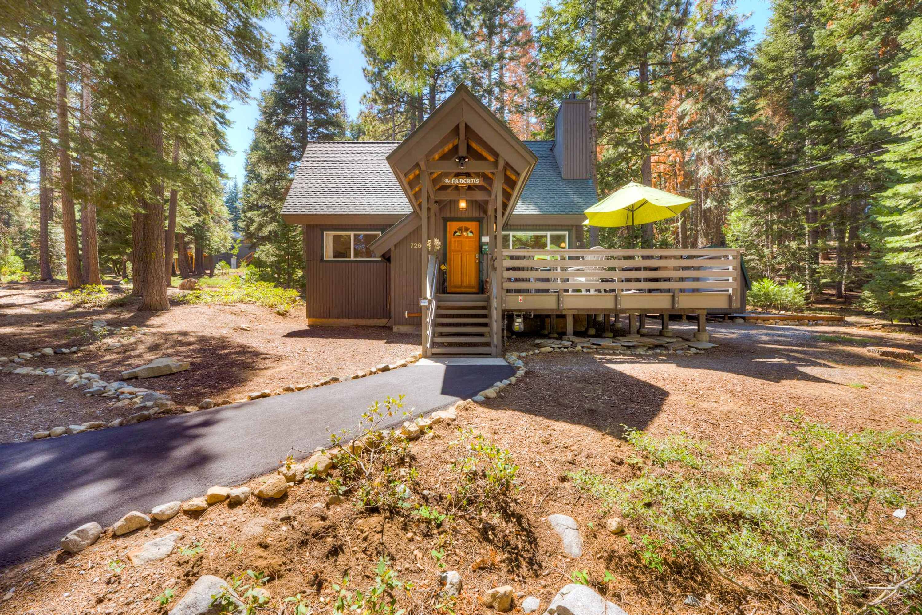 A lodge with a wooden entrance, a bench outside, and a paved path leading to the door.