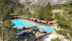 A resort with multiple swimming pools, lounge areas, and a mountainous backdrop. - Ski-in-ski-out studio in Everline Resort & Spa - pools, gym, tennis, ice rink (Olympic Valley)