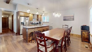 A spacious kitchen with wooden cabinets, a central island, and pendant lighting.