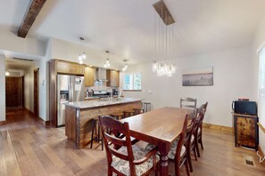 Une cuisine spacieuse avec des meubles en bois, un îlot central et des luminaires suspendus.