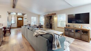 A living room with a sofa, a TV, a fireplace, and a dining area.