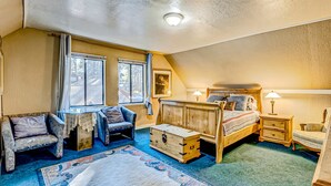 A bedroom with a bed, a nightstand, a dresser, a chair, a window, and a rug. - Dog Friendly Cabin with Hot Tub & Fireplace near Camp Richardson (South Lake Tahoe)