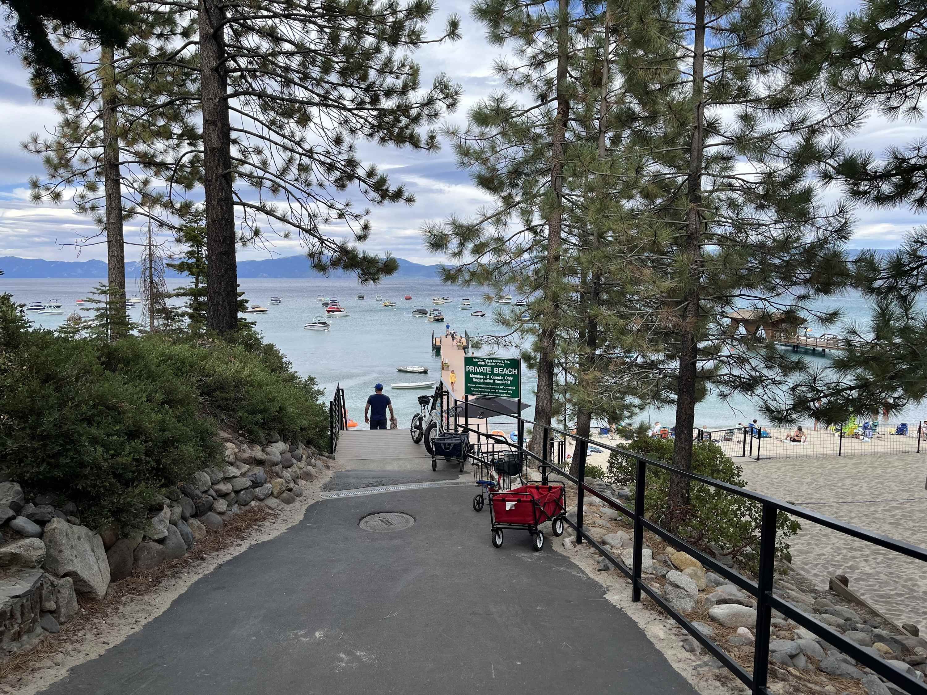 A pathway leading to a beach with a sign indicating it is a private beach.