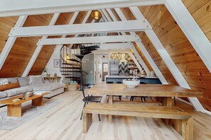 Ein Loft-Interieur mit Holzboden, einer Couch, einem Esstisch und einer Küchenzeile.