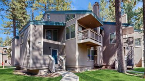 A multi-story residential building with a front entrance, a staircase, and a small porch area.