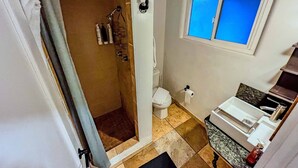 A bathroom with a shower, toilet, sink, and a window. - Pleasant hotel with lakeview, golf, skiing, WiFi, & Netflix (Kings Beach)