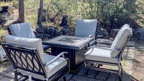 An outdoor patio with a table and four chairs, surrounded by rocks and trees. - Pleasant hotel with lakeview, golf, skiing, WiFi, & Netflix (Kings Beach)