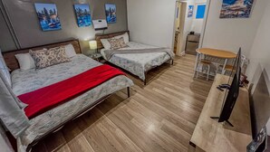 A hotel room with two beds, a desk with a computer, and a TV. - Pleasant hotel with lakeview, golf, skiing, WiFi, & Netflix (Kings Beach)