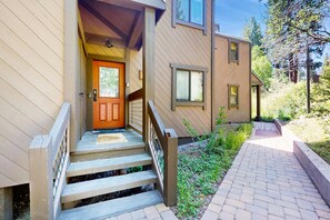 A wooden house with a front door, steps, and a brick pathway leading to it. - Mountain condo with access to outdoor pool, hot tub, tennis & sauna (NorthStar-Truckee)