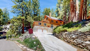 A two-story log cabin with a stone foundation, a stone retaining wall, and a driveway leading to a garage. - Stateline Chalet -  5BR, Panoramic Mountain Views, Dipping Pool & Dry Sauna (Stateline)