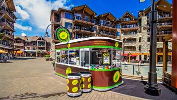 Un chariot de vente de nourriture, aménagé comme un tramway, avec des canettes de Coca-Cola, une enseigne indiquant les boissons chaudes et froides, et un panneau affichant le menu.