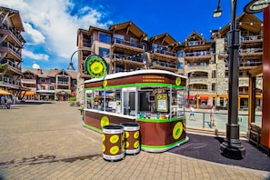A tram-style food cart with Coca-Cola cans, a sign for hot and cold beverages, and a menu board.
