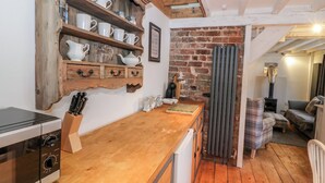 Eine Küche mit Holzböden, einer Kaffeemaschine und einer Ziegelwand.
