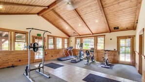 A gym with exercise equipment, wooden walls, and large windows. - Quiet Townhouse in Ideal Truckee Location with Pool, Hot Tub & Sauna (Truckee)