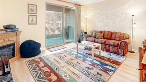 A living room with a sofa, coffee table, and a patterned rug. - Quiet Townhouse in Ideal Truckee Location with Pool, Hot Tub & Sauna (Truckee)