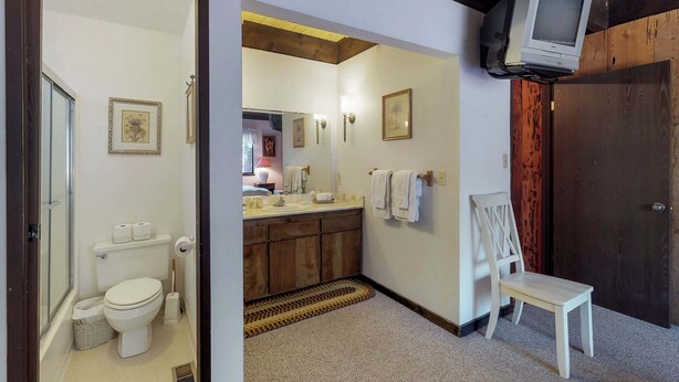 Une salle de bain avec des toilettes, un lavabo et un miroir.