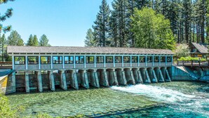 A long, narrow building with a roof and windows, supported by columns, over a body of water. - Remodeled Lake Tahoe Beach Condo - Pools, Tennis & Deck - Near Ski Resorts (Tahoe City)
