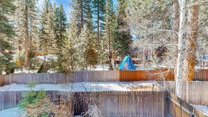 A fenced outdoor area with tall evergreen trees and a wooden deck. - Forest-view condo with wood fireplace & walkable locale - dog-friendly (Incline Village)