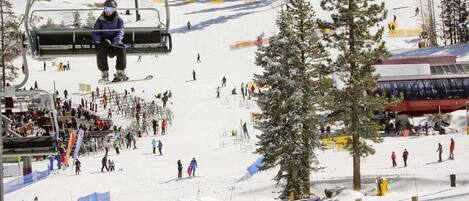 A ski slope with a ski lift, skiers, and a snow-covered landscape.