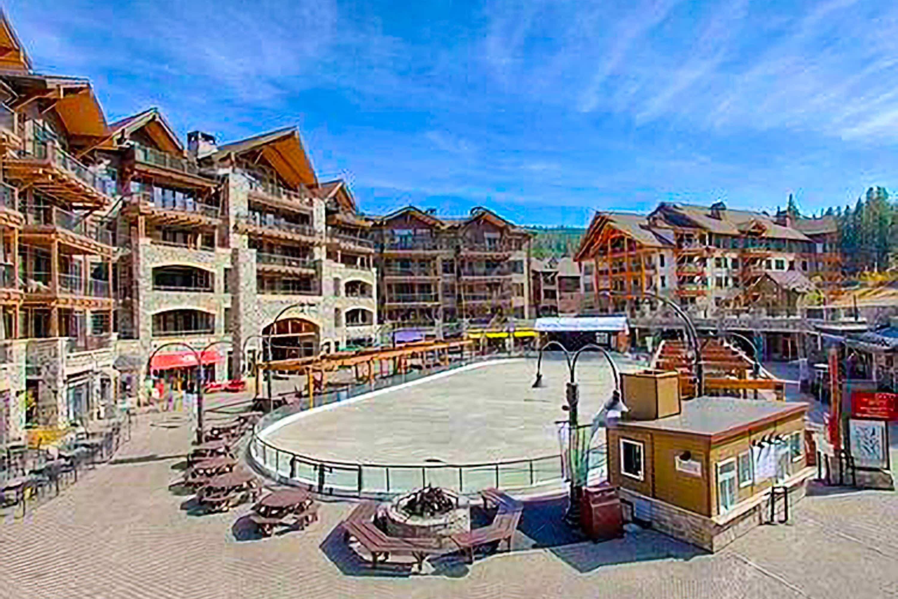 A resort with multiple-story buildings, outdoor seating areas, and a central plaza.
