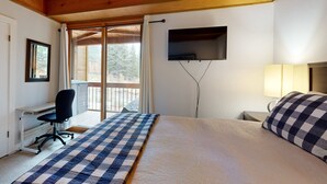 A bedroom with a bed, desk, chair, TV, and window. - Mountain Condo with Fireplace, Balcony, WiFi (NorthStar-Truckee)