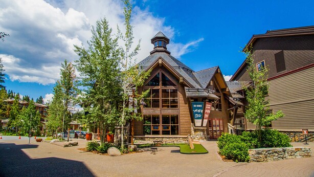 A lodge with a prominent tower, large windows, and a stone facade. - Mountain Condo with Fireplace, Balcony, WiFi (NorthStar-Truckee)