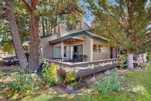 Een modern huis met een overdekte veranda, grote ramen en een verzorgde tuin.