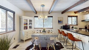 A modern kitchen with a central island, bar stools, and a cowhide rug. - Family-friendly cabin with fireplace, bikes, loft, games, & skiing nearby (South Lake Tahoe)