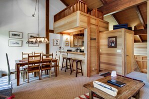 A rustic interior with a dining area, kitchen, and loft bedroom. - Truckee condo 1 mile from Northstar - ski, snowboard, or hike (NorthStar-Truckee)